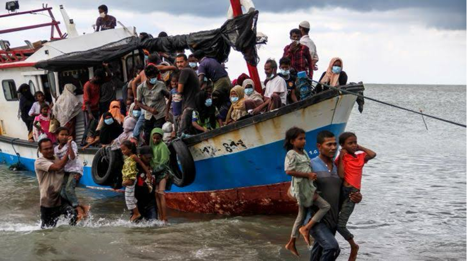 Indonesian fishermen carrying people ashore in Aceh (Photo Credit: Al Jazeera)