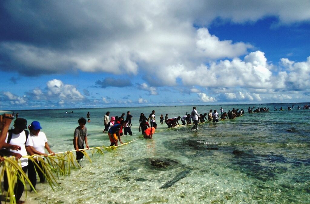 Customary elders and community members gathering on the shore in Maluku to conduct sacred rituals marking the opening (buka sasi) or closing (tutup sasi) of a protected marine zone (Photo Credit : The Guardian - Traditional Fisheries and Customary Law Archives)