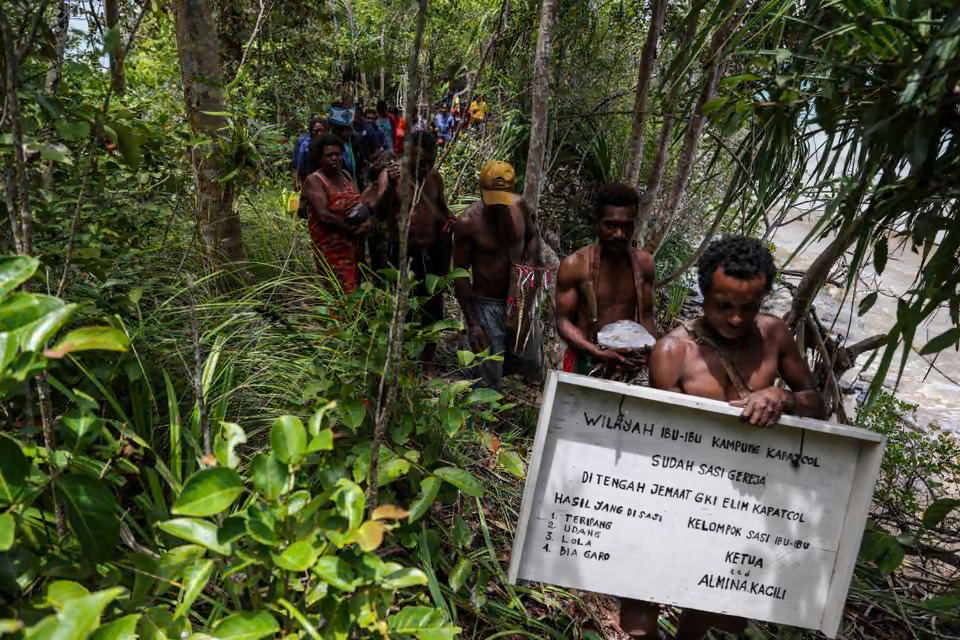 Local villages hold up Sasi boards indicating that fish and marine animals can be collected (Photo Credit : Garry Lotulung)